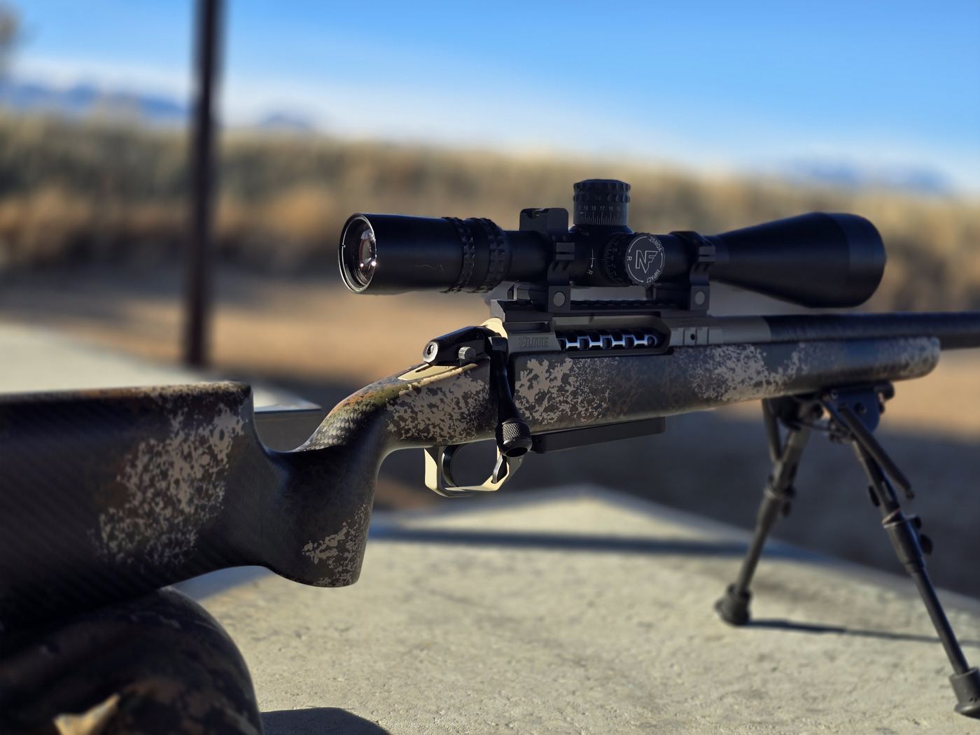 Bench rifle, carbon-fiber stock, Nightforce scope, ready on the bench